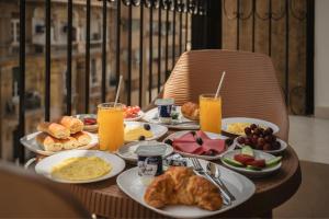 a table with breakfast foods and drinks on it at Royal Hotel in Cairo