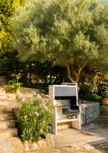 a white piano sitting in front of a tree at Villa Wanderlust Sitges Hills Exclusive pool only families in Olivella