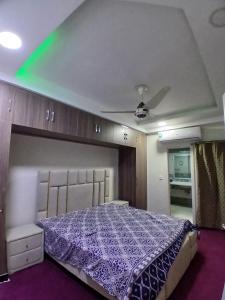 a bedroom with a purple bed and a ceiling at Cottage Inn in Faisalabad +1 photo