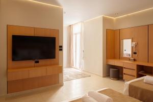 a living room with a flat screen tv and a bed at Royal Hotel in Cairo