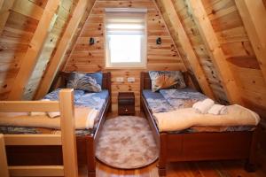 two bunk beds in a log cabin with a window at Zekova Valley Cabin Durmitor in Žabljak