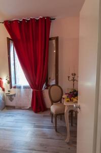 einen roten Vorhang in einem Zimmer mit einem Tisch in der Unterkunft Ca Bea in Venedig