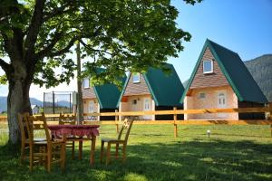 a table and chairs under a tree in front of a house at Zekova Valley Cabin Durmitor in Žabljak