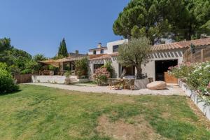 a backyard with a table and chairs and a house at L'hôtel des oiseaux in Les Baux-de-Provence