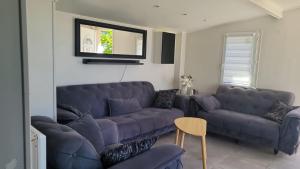 a living room with a couch and a table at Maison 7 personnes avec piscine proche de Disneyland Paris in Villiers-sur-Morin