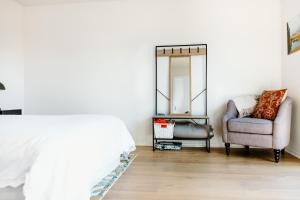 a bedroom with a bed and a chair and a mirror at The Albert Studio in Albert Town +1 photo