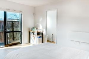 a bedroom with a white bed and a window at The Albert Studio in Albert Town