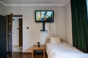 a room with a tv on a wall with a bed at Apartament Ogrodowa in Muszyna