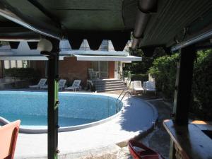 a swimming pool with chairs next to a house at Hostel Papagal in Varna City