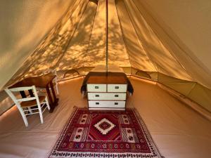a room with a table and a rug in a tent at Natur'O Médoc in Naujac-sur-Mer