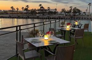 two tables with wine glasses on a balcony with the water at Master&Commander in Valencia