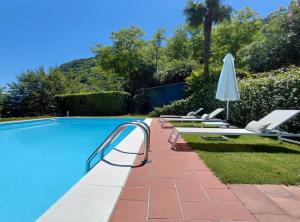 ein Swimmingpool mit Liegestühlen und einem Sonnenschirm in der Unterkunft Villa Maria in Onno + 38 Fotos