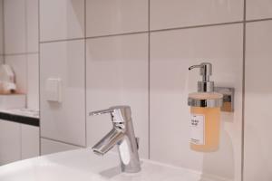 a bathroom sink with a soap dispenser on the wall at Albview-Apartment1 -zentral-Nähe Klinik-Therme-Agilent in Waldbronn +79 photos