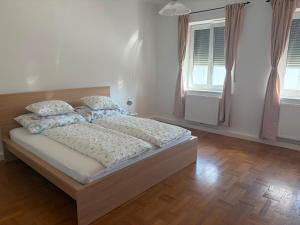 a bedroom with a bed with white sheets and pillows at Ferienwohnung Zum alten Postamt in Mörbisch am See