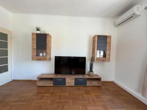 a living room with a flat screen tv on a white wall at Ferienwohnung Zum alten Postamt in Mörbisch am See