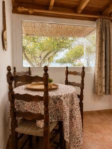 a dining room with a table and a window at The simple two-bedroom house at Klima Beach in Samos