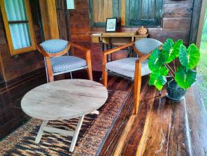 a room with two chairs and a table and a table and a plant at Tamarind nest in Sai Yok +11 photos