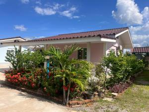 a house with flowers and plants in front of it at 226 House Ao Noi in Ban Don Hiang