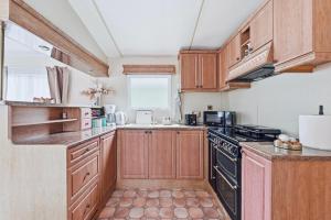 a kitchen with wooden cabinets and a stove top oven at Vagunmaja in Haapsalu