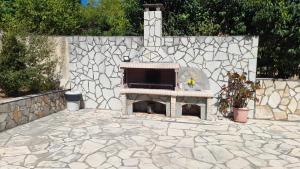 a stone patio with a fireplace in front of a stone wall at Villa Eleftheria in Karavomylos +29 photos