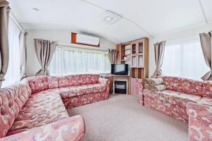 a living room with a couch and a tv at Vagunmaja in Haapsalu +6 photos