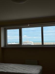 a room with three windows with a view of the beach at Двоповерхові апартаменти в яхт-клубі in Odesa