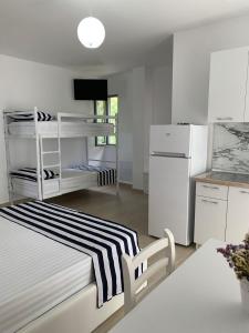 a white room with a bed and a kitchen at Vila Kalluci in Borsh