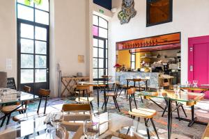 a restaurant with tables and chairs and a counter at Hôtel du Parc in Arles