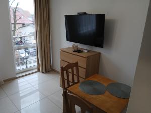 a dining room with a table and a flat screen tv at Apartament 112 Mielno in Mielno