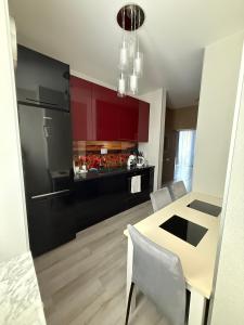 a kitchen with red cabinets and a table and chairs at Lielais prospekts 54 in Ventspils