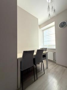 a dining room with a table and chairs and a window at Lielais prospekts 54 in Ventspils +10 photos