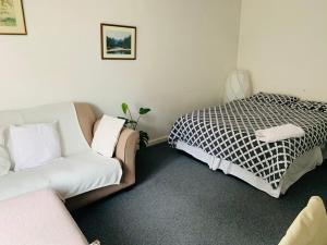 a living room with a couch and a bed at Bramley Fall Park Homestay in Horsforth