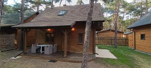 a log cabin with a table on a deck at Domek w Sielpi in Sielpia Wielka