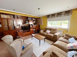 a living room with two couches and a tv at Casa María B - a 3km del Camino in Santa Eulalia
