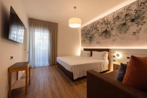 a hotel room with a bed and a couch at Hotel Capanna d'Oro in Lignano Sabbiadoro +86 photos