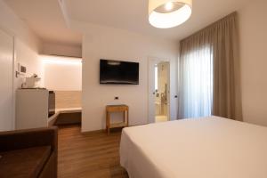 a hotel room with a bed and a television at Hotel Capanna d'Oro in Lignano Sabbiadoro