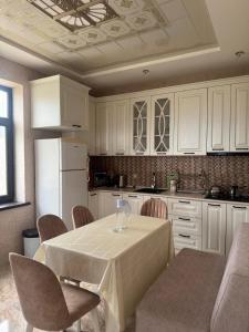 a kitchen with a table with chairs and a refrigerator at Caspian Seaside Villa in Sumqayıt