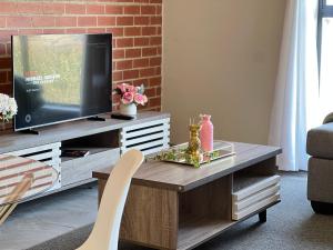 a living room with a television on a wooden table at Luxury Apartment Overlooking the River in Midrand