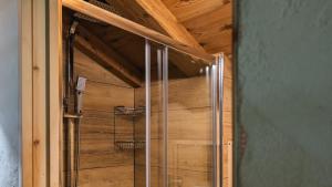 a glass shower in a room with a wooden ceiling at Tilio Chalet in Livigno +32 photos