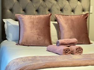 a bed with two towels and pillows on it at Luxury Apartment Overlooking the River in Midrand