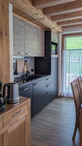 a kitchen with stainless steel appliances and a wooden floor at Tilio Chalet in Livigno