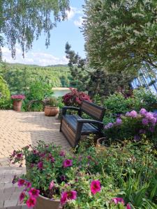 a bench sitting in the middle of a garden with flowers at Mała Garda in Brodnica Dolna