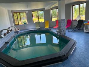 a large swimming pool in a room with colorful chairs at Weinesya Sunset Smida in Beliş