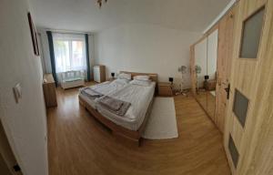a bedroom with a large bed and a wooden floor at Apartman Kováčová in Kováčová