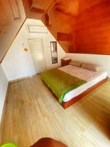 a bedroom with a bed in a room with a wooden ceiling at Laendra Sunset Karimunjawa in Karimunjawa