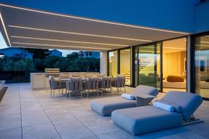 a patio with chairs and a table and a bar at Villa FUX Eternity 3 in Ždrelac