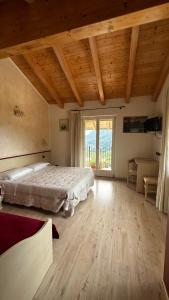 a bedroom with a bed and a large window at Agritur Due Valli in Livo