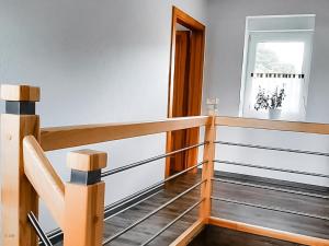 a staircase in a room with white walls and wood at Ferienhaus Flotte Biene Buggow nahe Usedom in Rubkow