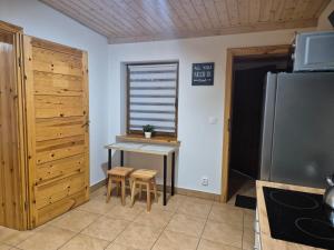 a kitchen with a small table and a refrigerator at Apartment Pod Modrzewiem in Powidz +4 photos