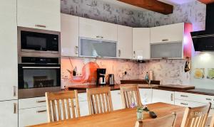 a kitchen with a wooden table and chairs at Ferienhaus Flotte Biene Buggow nahe Usedom in Rubkow